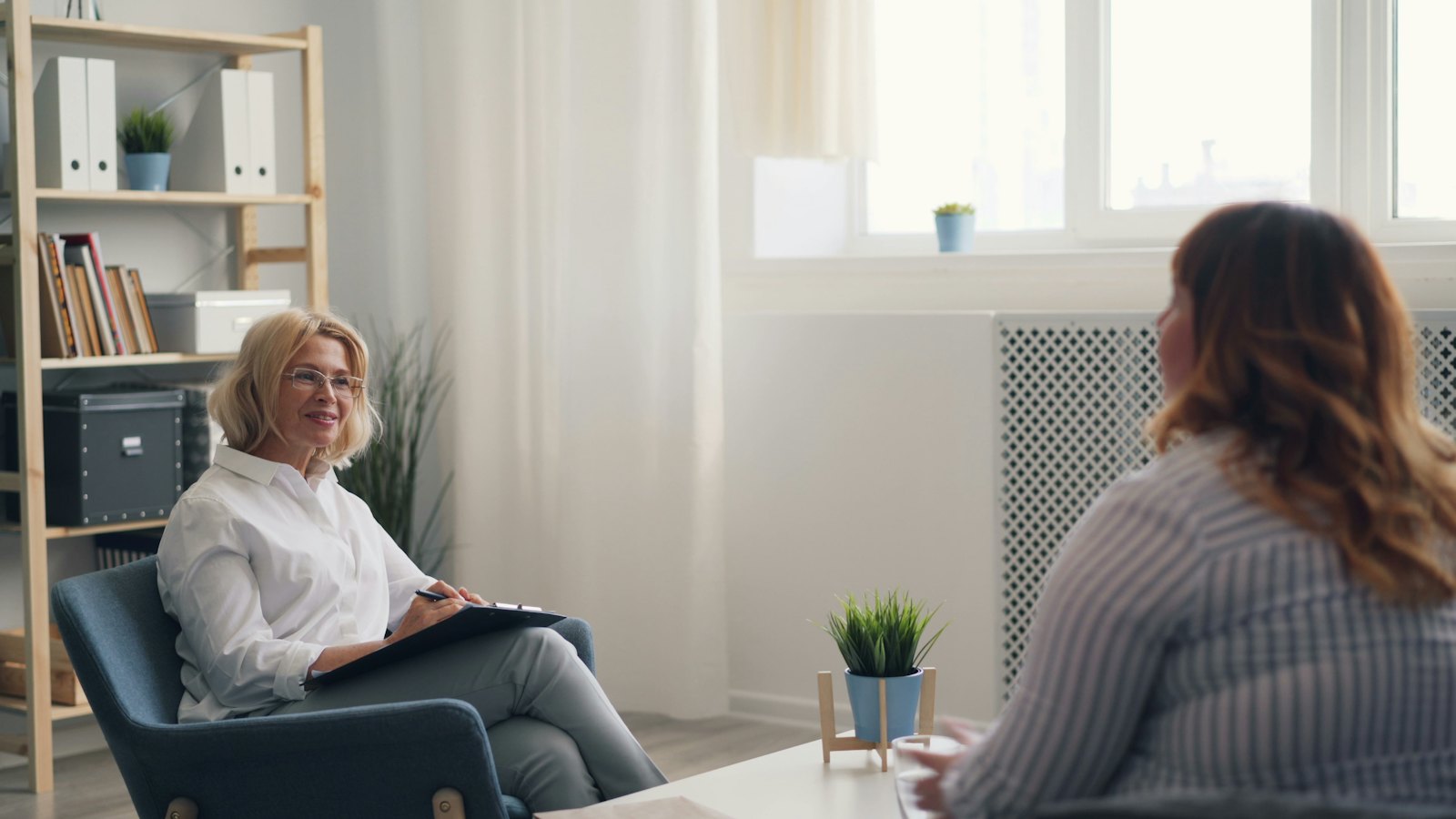 Two people talking calmly in a bright room